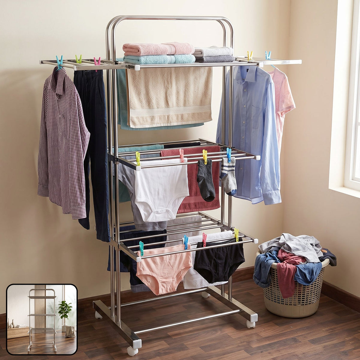 A stainless steel 3-layer clothes drying rack with various clothing items, including shirts, towels, and underwear.