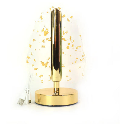 A close-up of the golden base and stem of the crystal leaf LED lamp with a white USB cable on a white background.