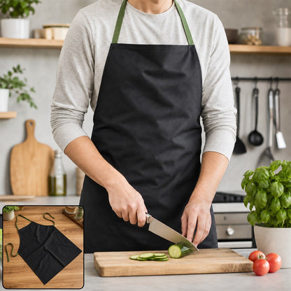 A person in a light grey long-sleeved shirt and a black apron with green straps is slicing a cucumber on a wooden cutting