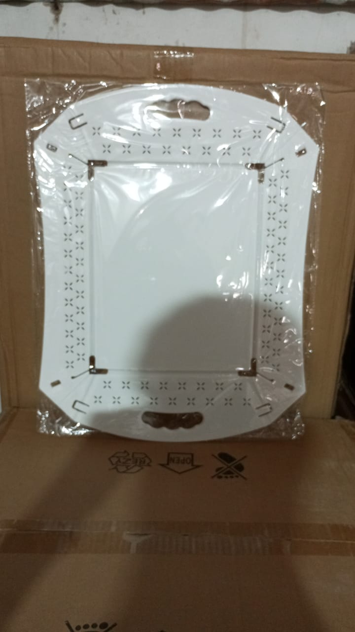 A white foldable serving tray is sealed in clear plastic packaging, resting on cardboard boxes.