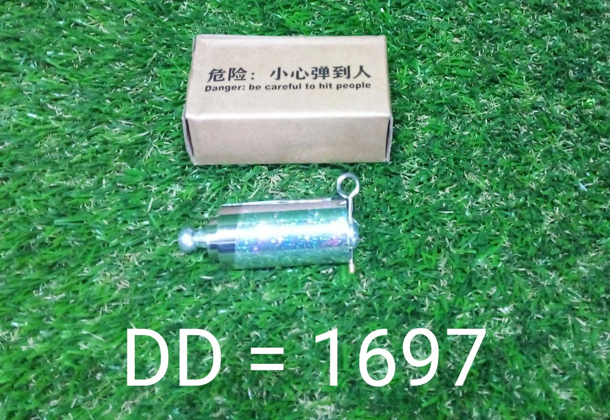 A silver collapsible cane and its cardboard box resting on a vibrant green grass surface.
