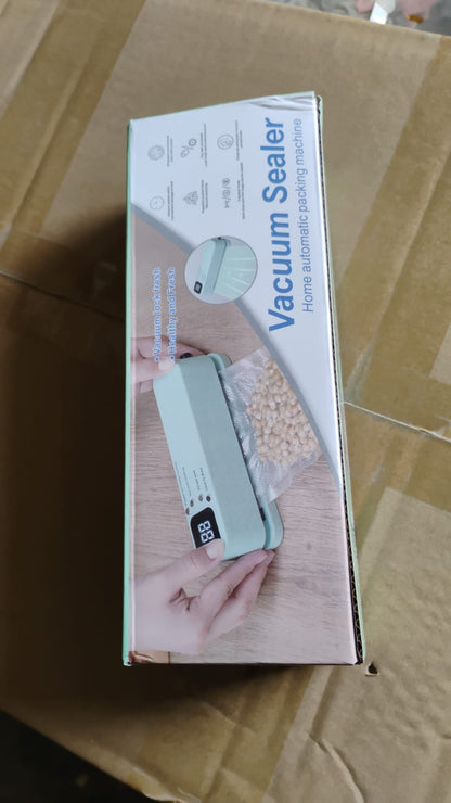 The product box for the mint green vacuum sealer, displaying product features and an image of the sealer in use.
