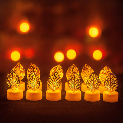 Twelve golden leaf LED candles glowing on a dark surface, with multiple blurred warm lights in the background.