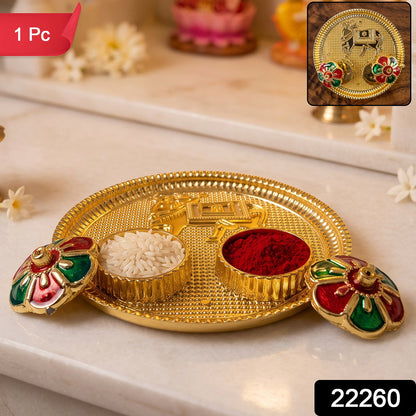 A golden pooja thali with a cow design, two small bowls of rice and kumkum, and two flower-shaped lids, with a red "1 Pc"