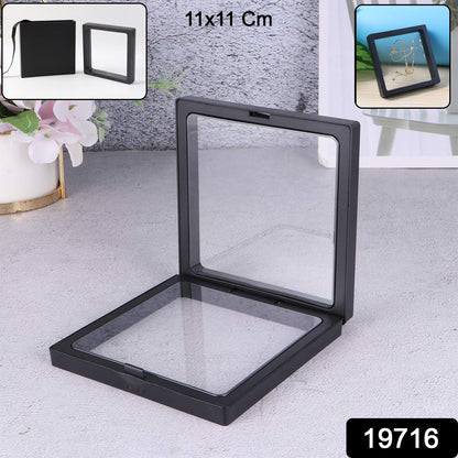 Open black square display box with clear film, showing its empty interior on a grey table.