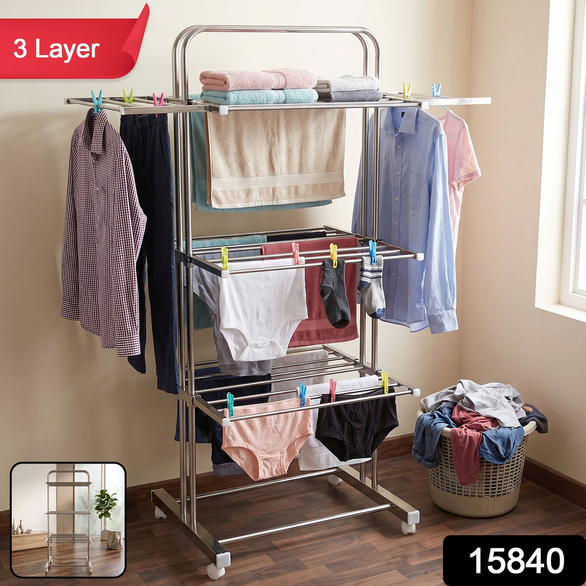A stainless steel 3-layer clothes drying rack with various clothing items, including shirts, towels, and underwear, hanging