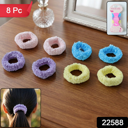 Eight fluffy elastic hair bands in pink, purple, blue, and yellow are displayed on a wooden surface.