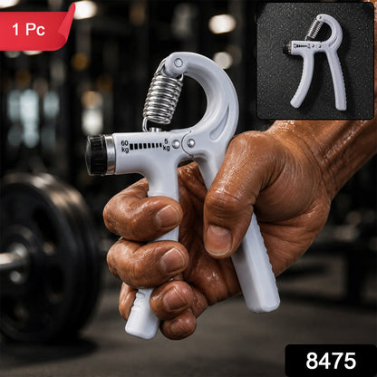 A person's hand holds a white adjustable grip strength trainer with a metal spring in a gym setting, with a small inset