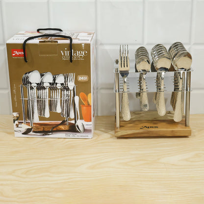 A 24-piece hammered stainless steel cutlery set with a wooden stand next to its product box on a light wooden surface. The