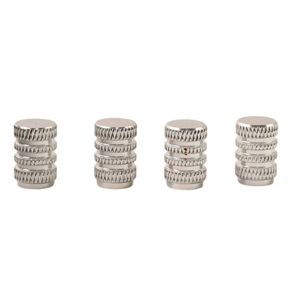 Four silver, textured, cylindrical valve caps standing upright on a white background.